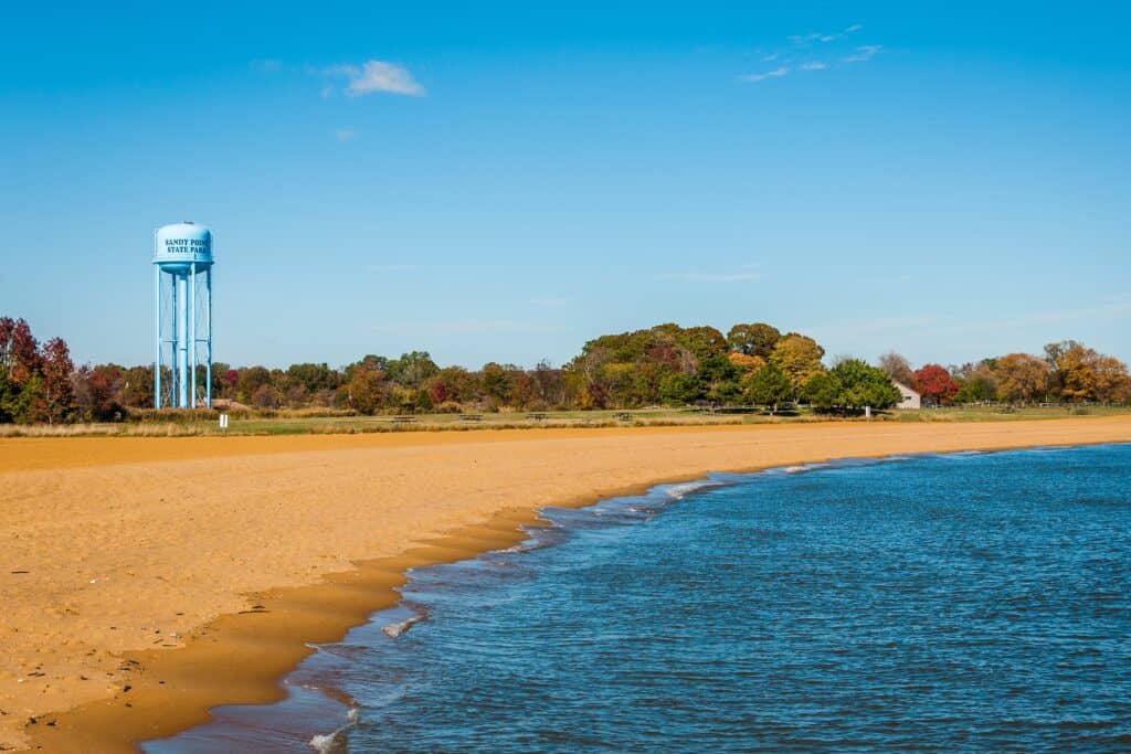 Una torre dell'acqua su una spiaggia con alberi sullo sfondo