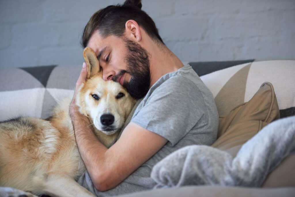 uomo che stringe a sé un cane