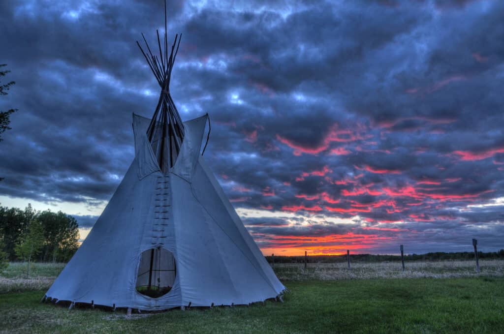 Tipi indiani tradizionali della prima nazione sotto il tramonto al sito storico nazionale della casa di montagna rocciosa in Alberta, Canada