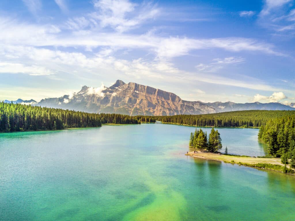 Lago Minnewanka circondato da cime montuose e foreste.