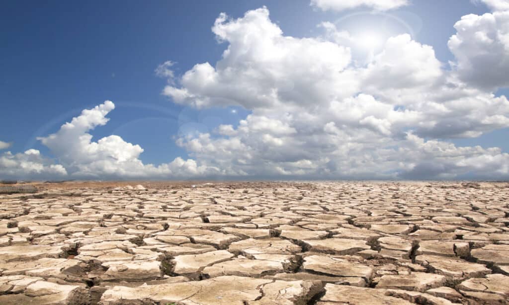 Terra di siccità contro un cielo blu con nuvole
