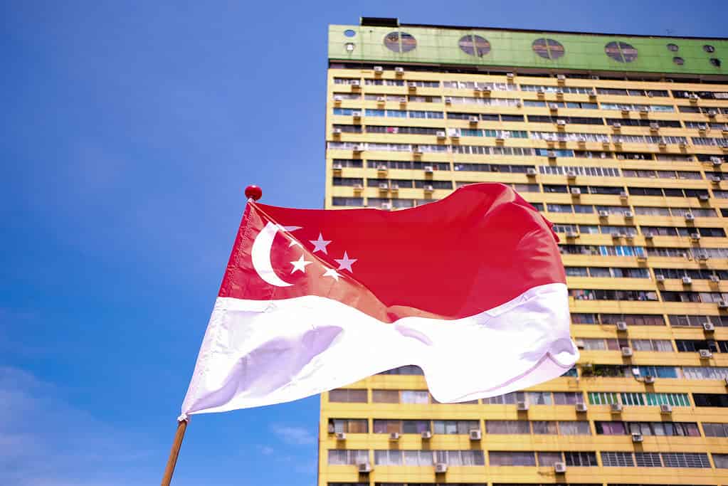 Bandiera di Singapore che fluttua nel vento sullo sfondo del vecchio edificio del parco della gente