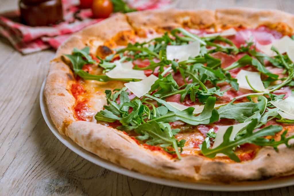 Rucola fresca che guarnisce una pizza