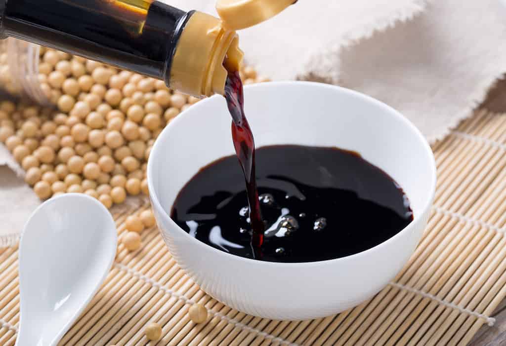Versare la salsa di soia in una ciotola bianca