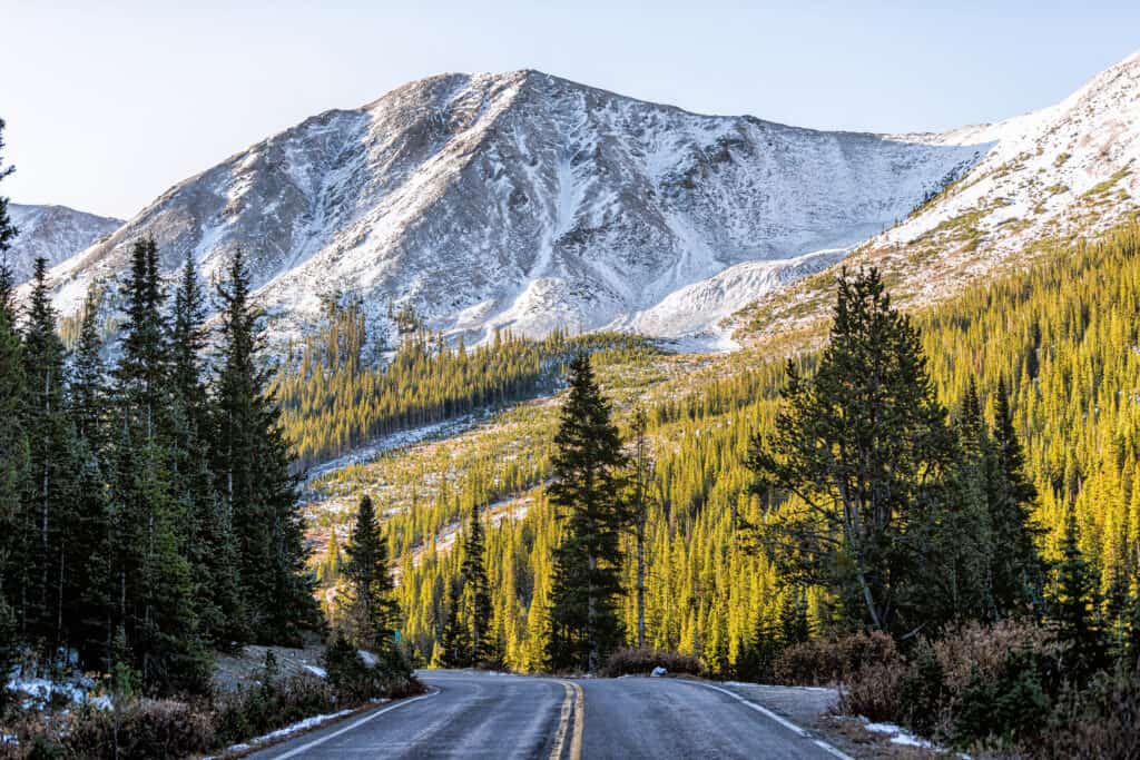 Independence Pass neve vista sulle montagne rocciose e strada asfaltata scenic byway all'alba del mattino vicino Aspen, Colorado nel verde autunno inverno