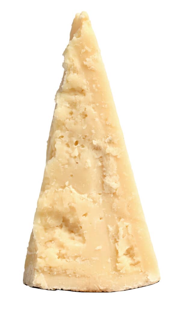 Un cuneo triangolare irregolare (non liscio) di formaggio romano giallo molto chiaro contro l'isolato bianco. 