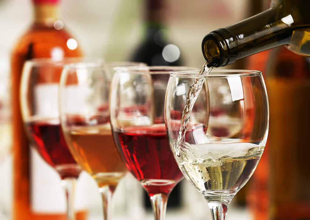 Vino bianco che versa nei bicchieri, primo piano