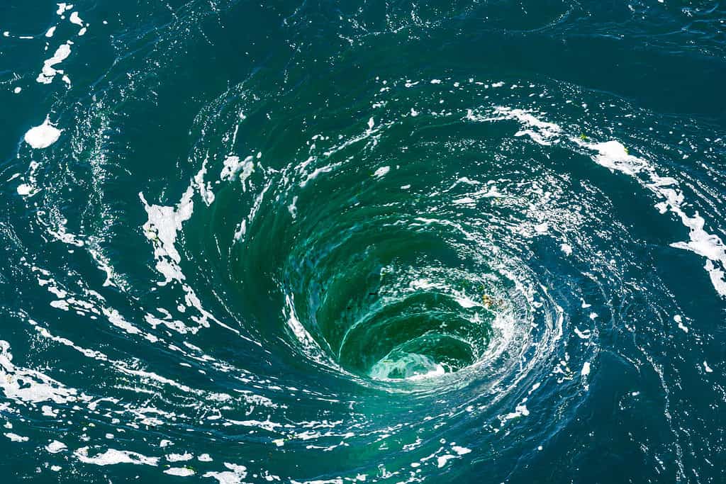 Veduta dall'alto di un potente idromassaggio sulla superficie dell'acqua verde con schiuma.