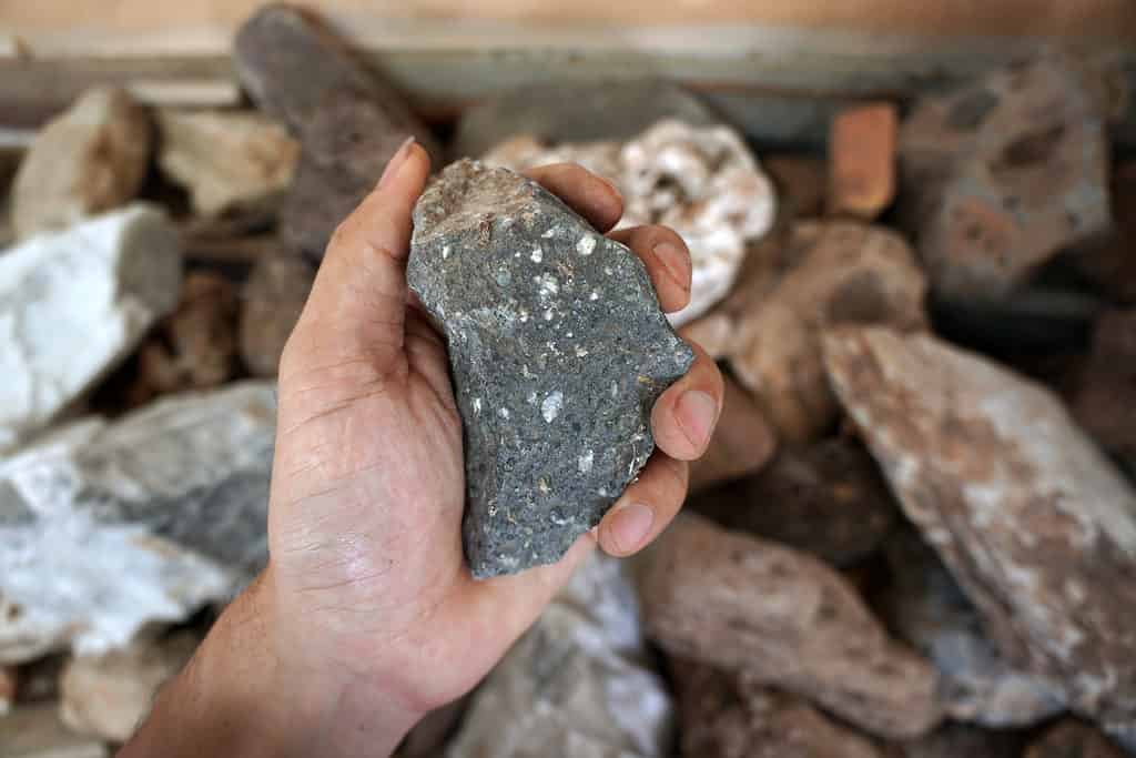 Una mano che tiene una pietra di andesite.