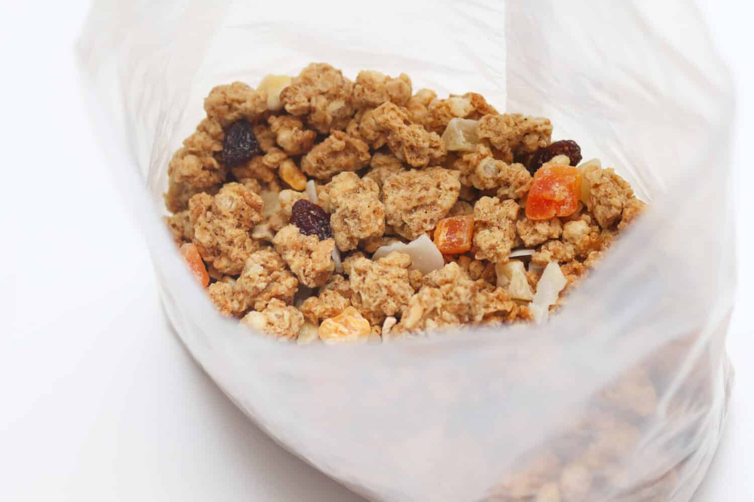 Muesli con frutta e noci in un sacchetto di plastica trasparente.  Miscela di muesli al forno.  Super concetto di cibo.  Cereali da colazione.  Dieta per bambini.