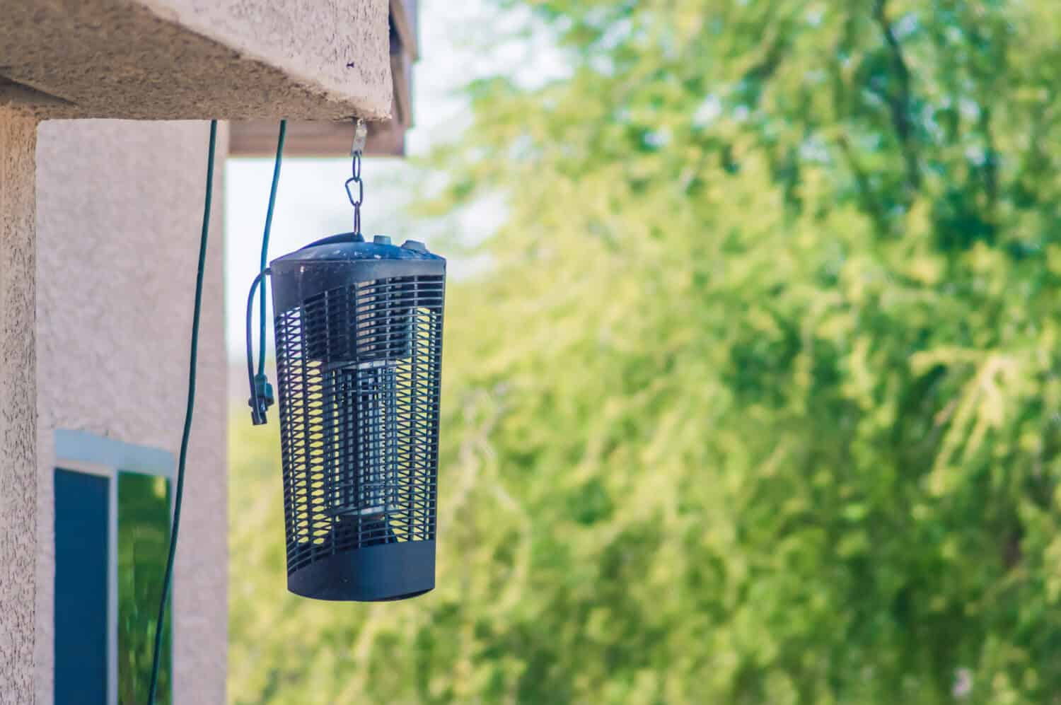 Un grande zapper per insetti appeso a una casa alla luce del giorno