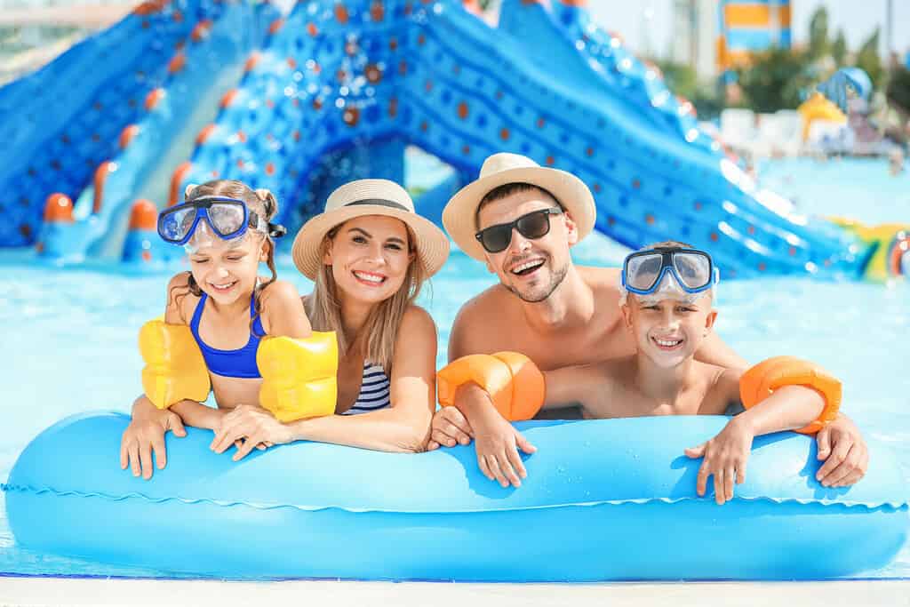 Famiglia felice che riposa nel parco acquatico
