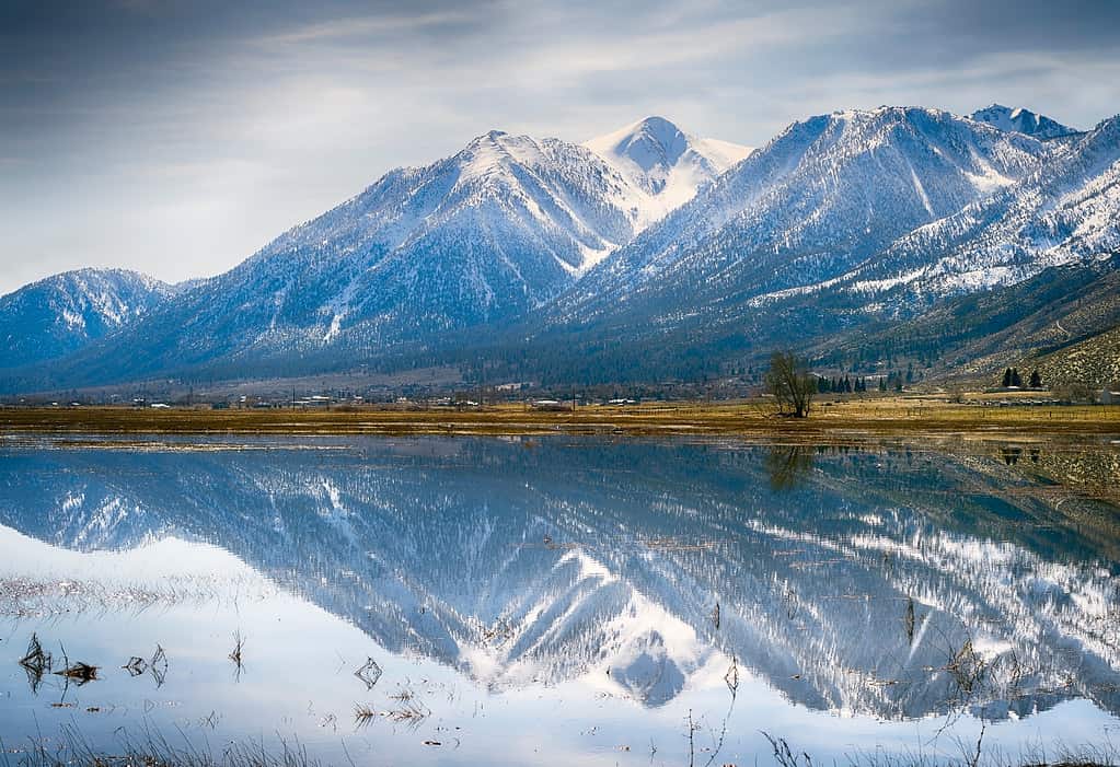 Bellissimi riflessi di montagne innevate in uno stagno tranquillo vicino a Genova, Nevada