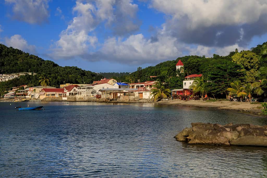 Il lungomare di Deshaies è immerso nel sole del tardo pomeriggio, la location di Saint Marie della serie TV Death In Paradise, sull'isola di Basse Terre in Guadalupa