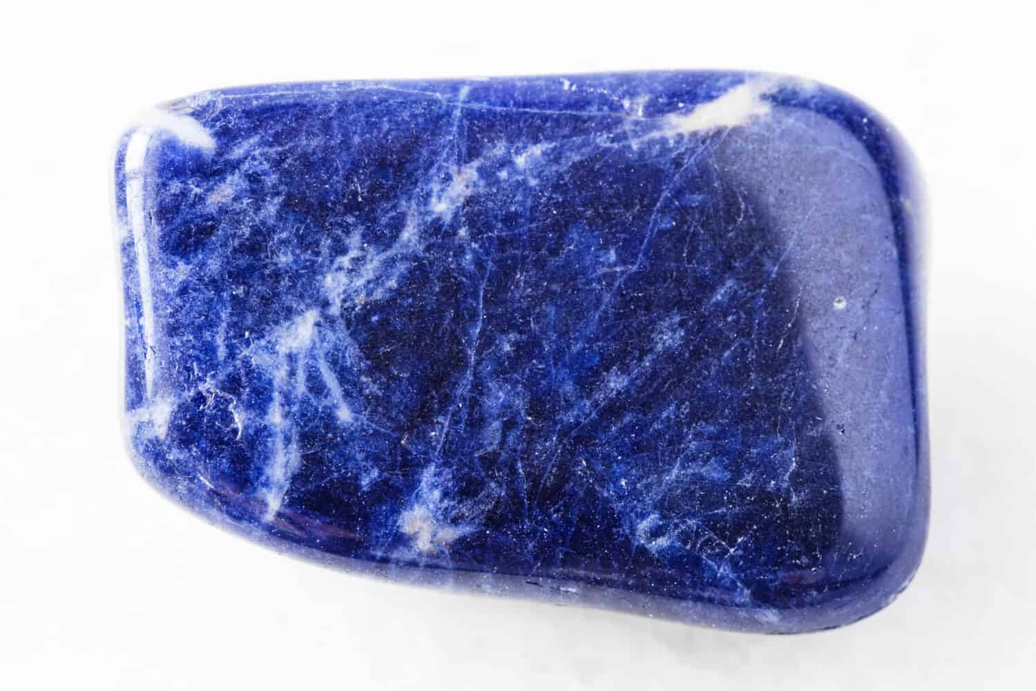 Primo piano di un campione di minerale naturale proveniente dalla collezione geologica - roccia Sodalite caduta su sfondo di marmo bianco dal Brasile
