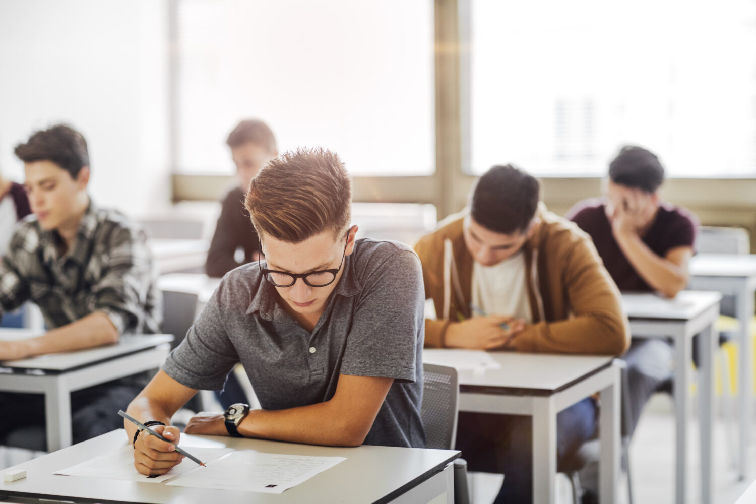 Gruppo di studenti delle scuole superiori che fanno l'esame in classe