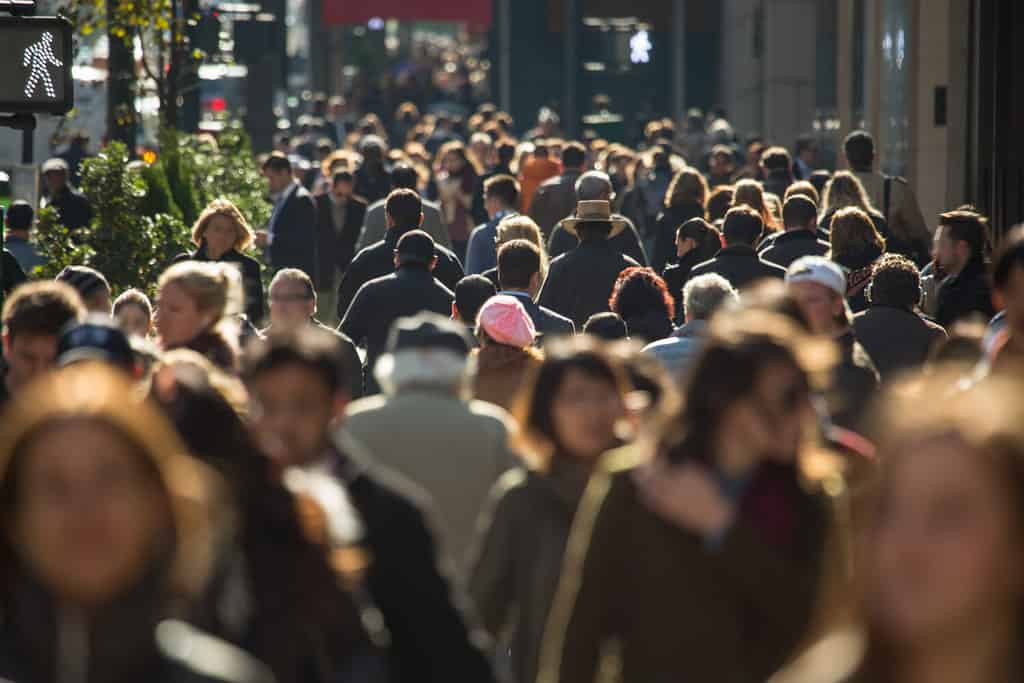 Folla di persone anonime che camminano sulla trafficata strada di New York City