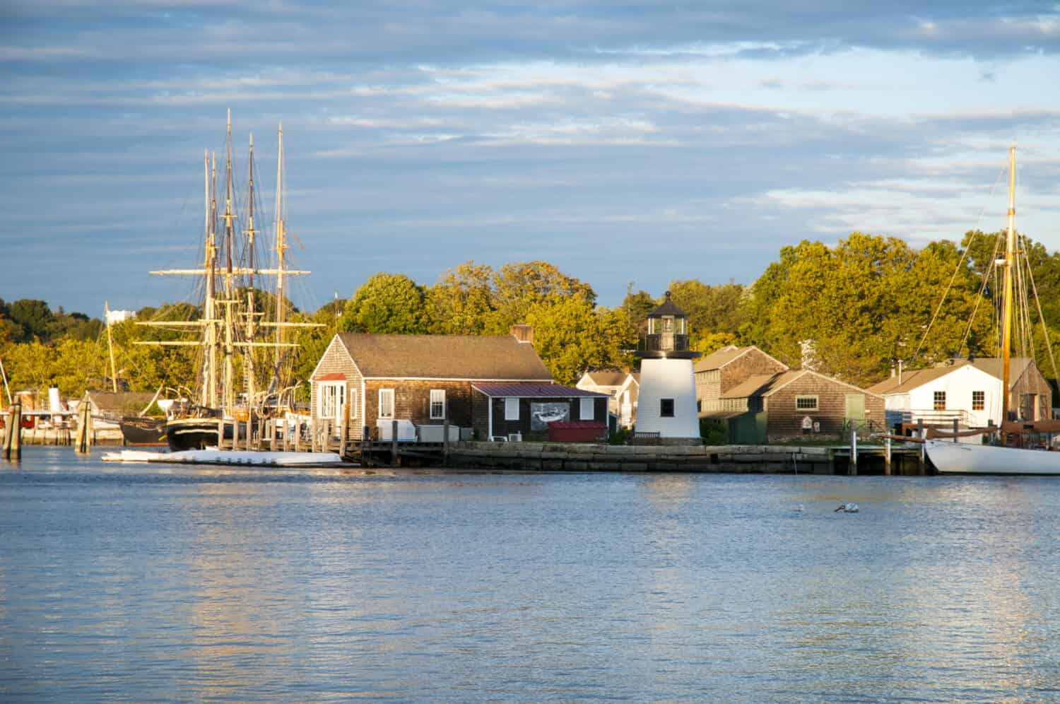 Tramonto di fronte a Mystic Seaport, un porto marittimo del XIX secolo ricreato all'aperto nel Connecticut. I visitatori troveranno una nave baleniera e una replica della luce di Brant Point dall'isola di Nantucket.