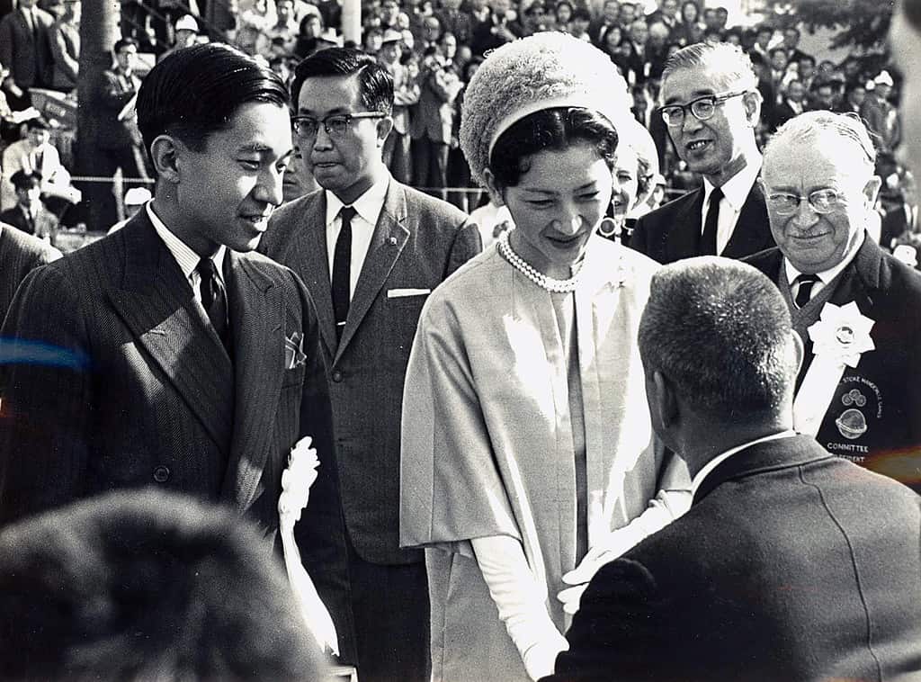 L'imperatrice Michiko e il principe ereditario Akihito (a sinistra) incontrano i rappresentanti delle squadre partecipanti durante la cerimonia di apertura dei Giochi Paralimpici di Tokyo del 1964 sull'Oda Field nel Parco Yoyogi, Tokyo. A destra dell'immagine c'è Ludwig Guttmann, il fondatore del movimento paralimpico.