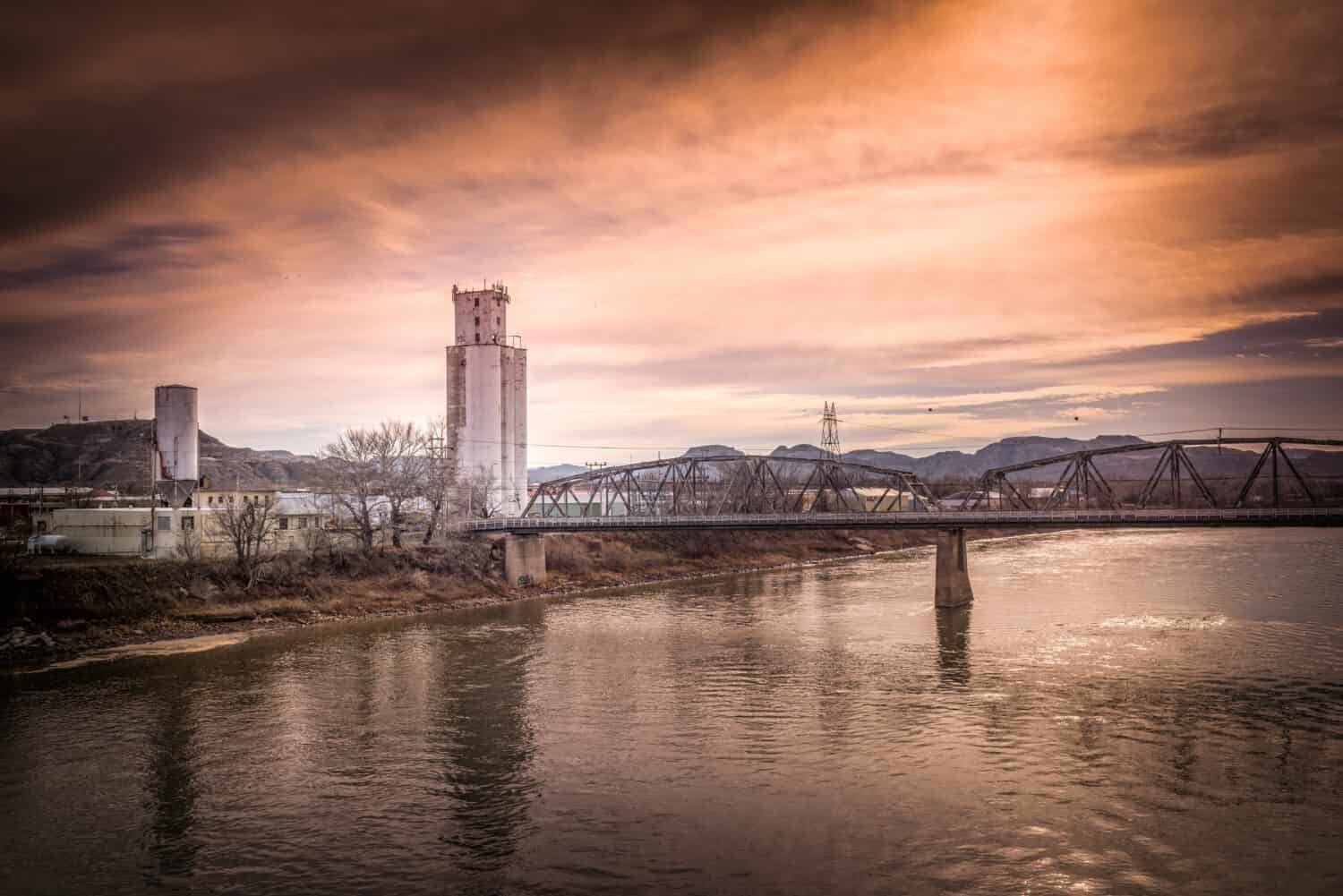 Fiume Yellowstone che scorre attraverso il paesaggio industriale con Rose Sunset - Glendive, Montana.