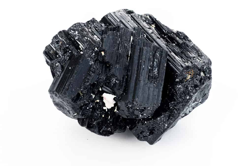 primo piano estremo del minerale di tormalina nera isolato su sfondo bianco nella tecnica di messa a fuoco