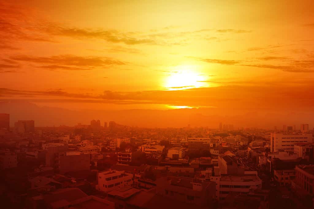 Ondata di caldo sulla città con lo sfondo del sole incandescente. Concetto di ondata di caldo