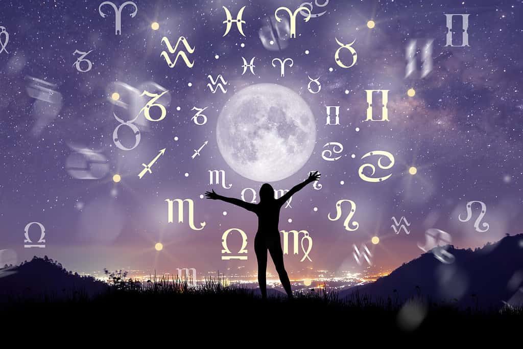 Segni zodiacali astrologici all'interno del cerchio dell'oroscopo.  Illustrazione della silhouette della donna che consulta le stelle e la luna sopra la ruota dello zodiaco e lo sfondo della Via Lattea.  Il potere del concetto di universo.