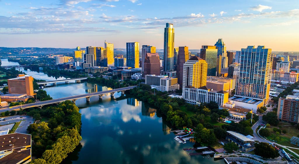 Paesaggio urbano dell'orizzonte dell'alba di Austin Texas USA sopra Town Lake o Lady Bird Lake con un'incredibile riflessione. Grattacieli e edificio della capitale del Texas in lontananza puoi vedere l'intera città durante l'estate