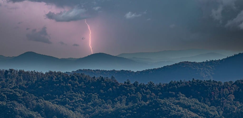 Un fulmine sulle colline nebbiose stratificate viste dalla strada panoramica Blue Ridge, North Carolina