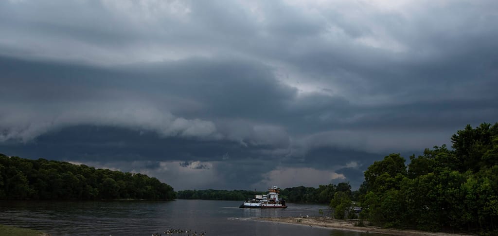 Una grande nuvola di scaffali che soffia sul fiume Tombigbee con una chiatta in vista.