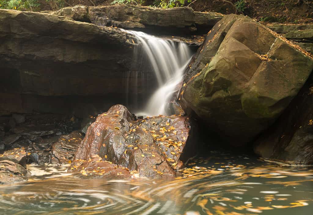 Cascata della cascata nel foro per nuotare con movimento sfocato su Deckers Creek che corre lungo il percorso 7 vicino a Masontown nella contea di Preston West Virginia