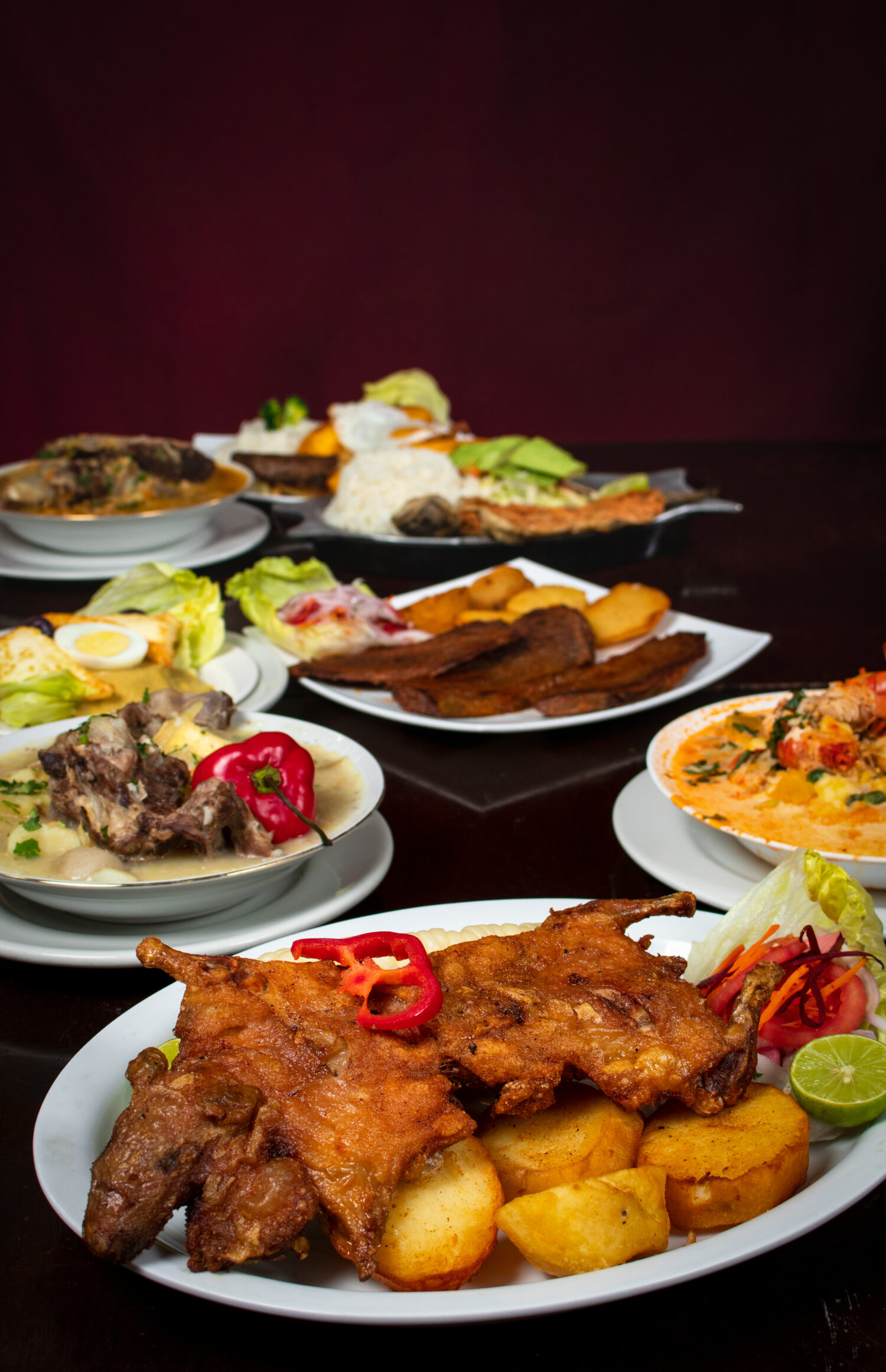 Cuy chactado, piatto peruviano su un tavolo di legno e altri cibi di Arequipa