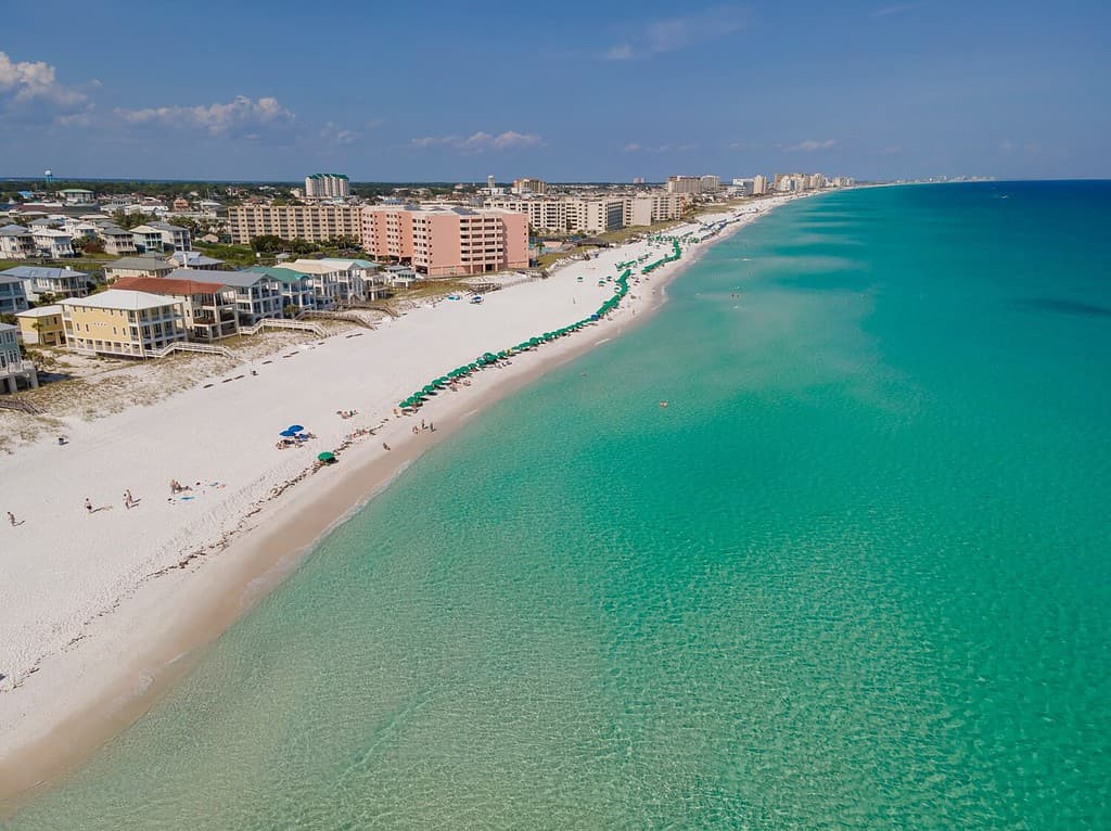 Bella vista aerea della spiaggia e dell'oceano a East Jetty a Destin Florida.  Paesaggio naturale panoramico con edifici e case che si affacciano sulla costa sabbiosa e sull'acqua pulita.