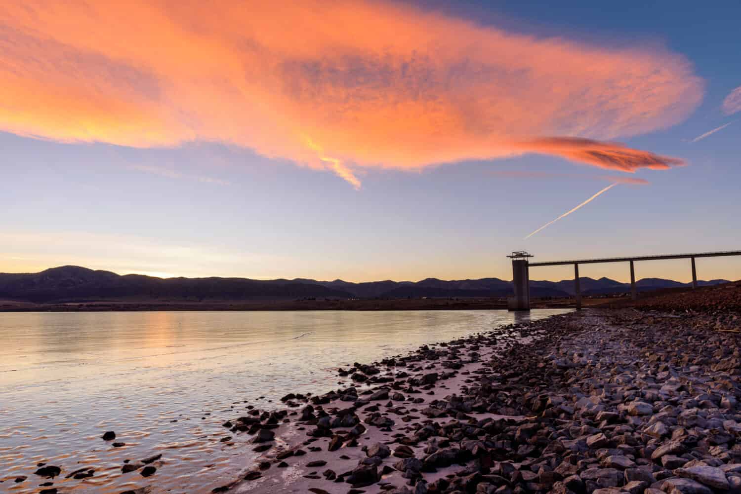 Sunset Chatfield Reservoir - Colorate nuvole al tramonto invernale che rotolano sopra il Chatfield Reservoir ghiacciato ai piedi della gamma anteriore delle Montagne Rocciose.  Chatfield State Park, Denver-Littleton, Colorado, Stati Uniti d'America.