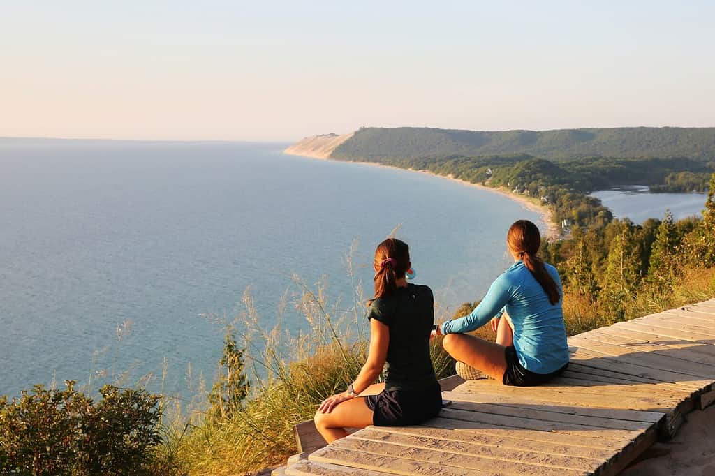 Turisti che si godono lo splendido scenario del tramonto all'Empire Bluff Scenic Lookout, con vista sul Lago Michigan, sulle Sleeping Bear Dunes e sull'Isola di Manitou