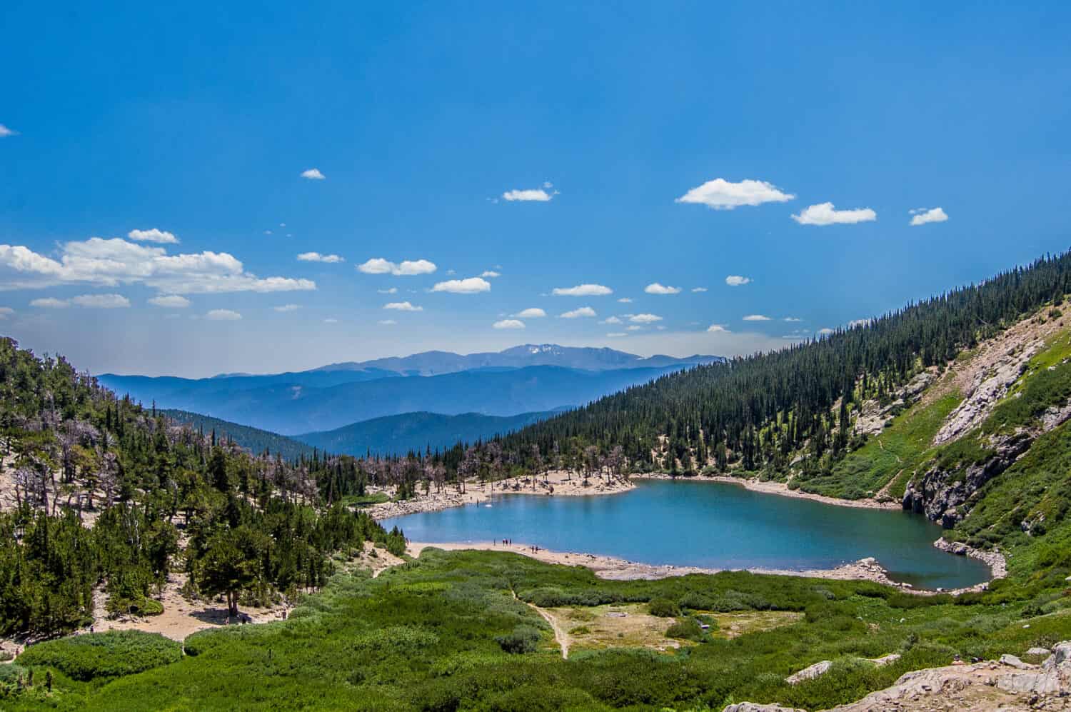 Il lago e i boschi appena sotto la neve che si scioglie del ghiacciaio St. Mary in Colorado.