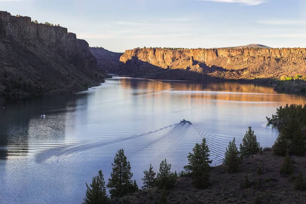 Barca a motore sul bellissimo lago al tramonto. Lago Billy Chinook nell'Oregon, USA, il parco statale di Cove Palisades