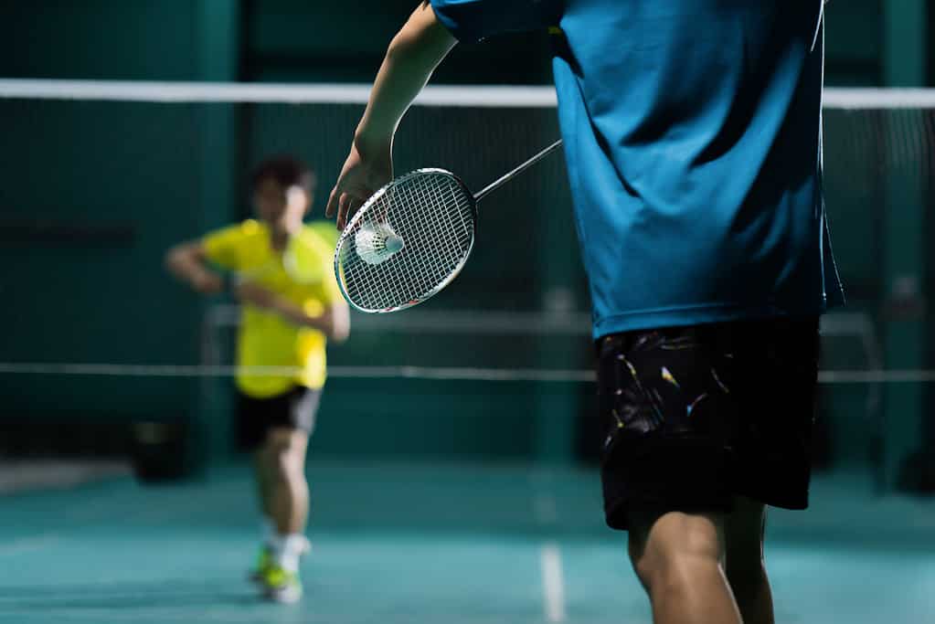 Giocatori di badminton impegnati in una partita. 