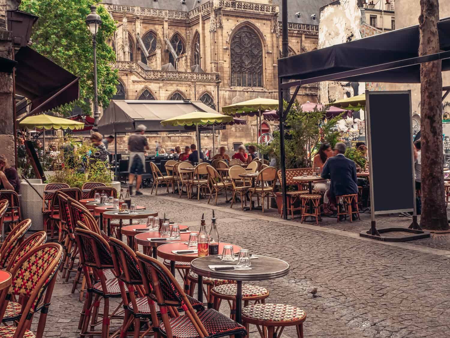 Strada accogliente con tavolini di un bar a Parigi, Francia. Architettura e monumenti di Parigi. Cartolina di Parigi