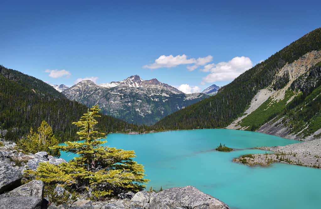 Un bellissimo lago glaciale in Canada. Il turchese lago Joffre è circondato dalla foresta pluviale. Cime delle montagne sullo sfondo. Parco provinciale dei laghi Joffre. Columbia Britannica, Canada.