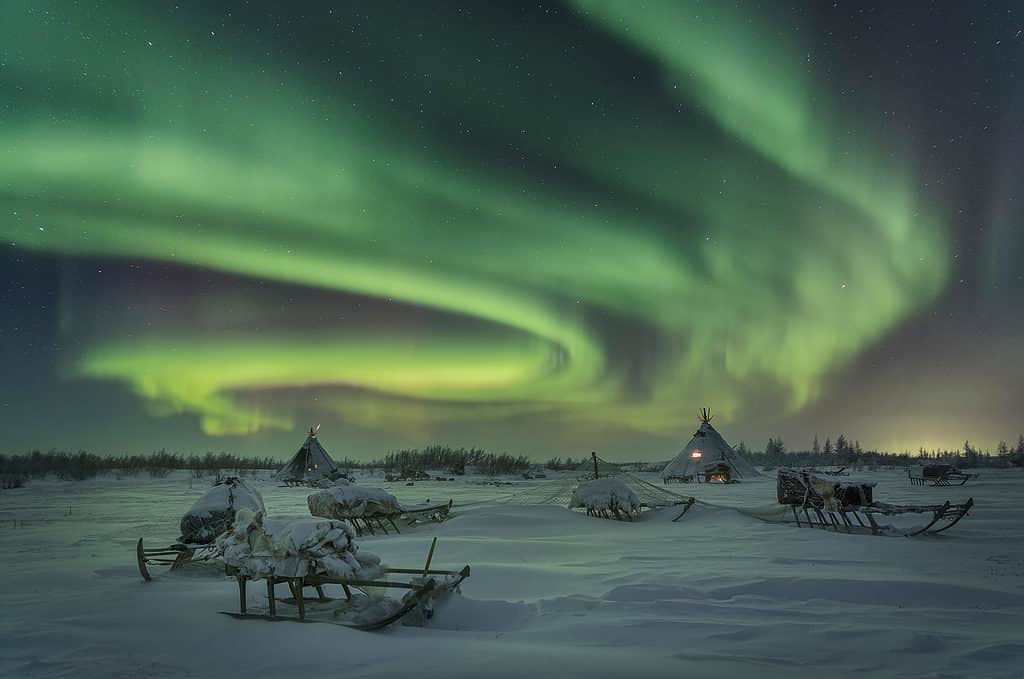 Notte gelida e limpida e luminosa aurora boreale nel campo dei pastori di renne nella penisola di Yamal. Russia.