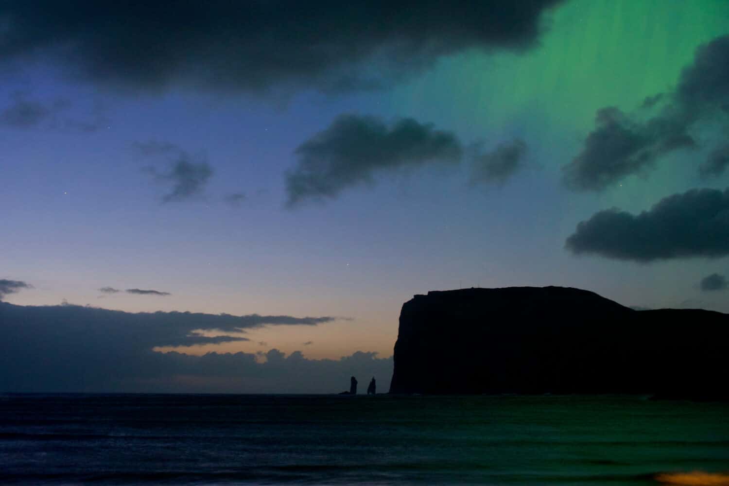 Aurora boreale sul mare nella città di Tjornuvik, Isole Faroe