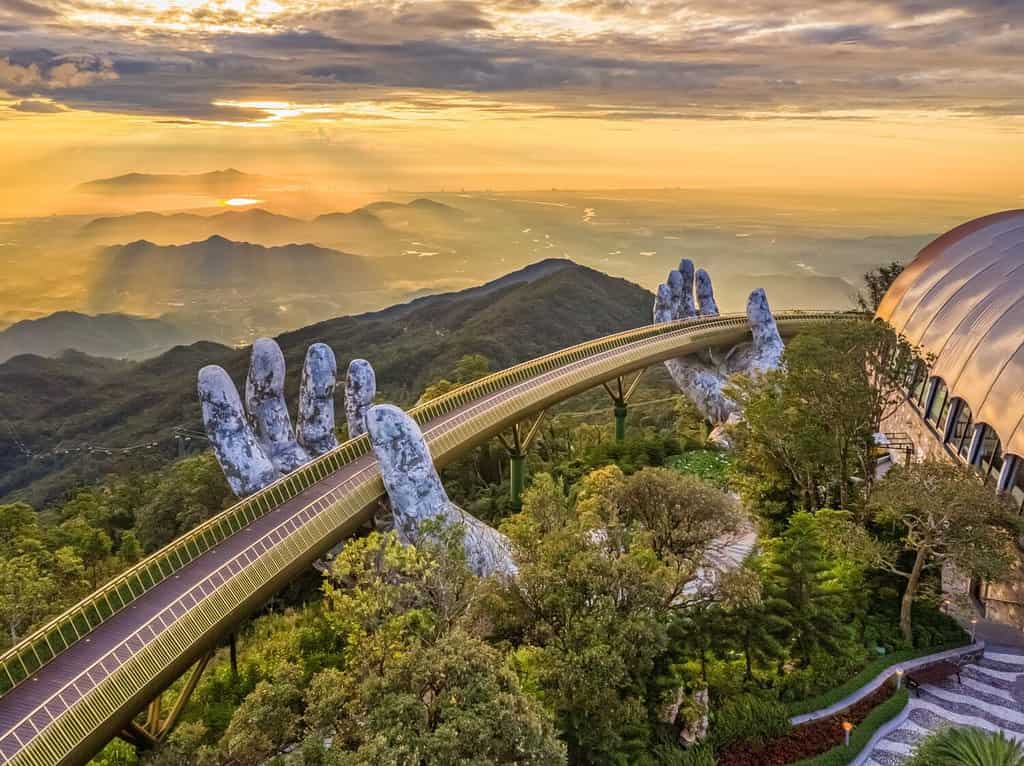 La vista aerea del Ponte d'Oro viene sollevata da due mani giganti nella località turistica sulla collina Ba Na a Da Nang, Vietnam. La località montana di Ba Na è una delle destinazioni preferite dai turisti