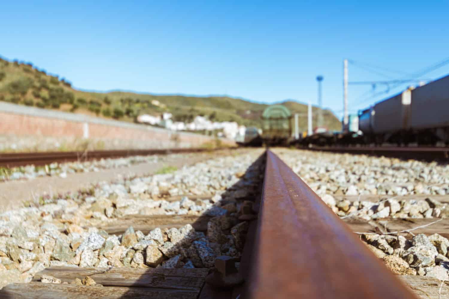 Stazione ferroviaria, treni merci, trasporto persone e rotaie.