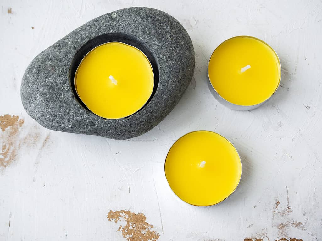 Candele anti-zanzara alla citronella su sfondo rustico bianco