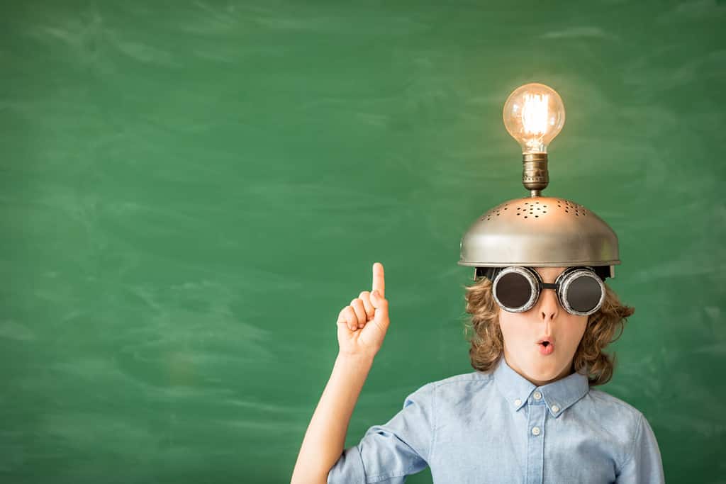 Ritratto di bambino in aula. Bambino con le cuffie da realtà virtuale giocattolo in classe. Successo, idea e concetto di tecnologia dell'innovazione. Di nuovo a scuola. Capretto contro la lavagna con spazio di copia