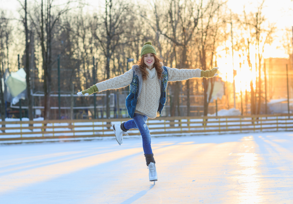 Bella ragazza che si diverte a Winter Park, in equilibrio mentre pattina sulla pista di pattinaggio. Godersi la natura, l'inverno