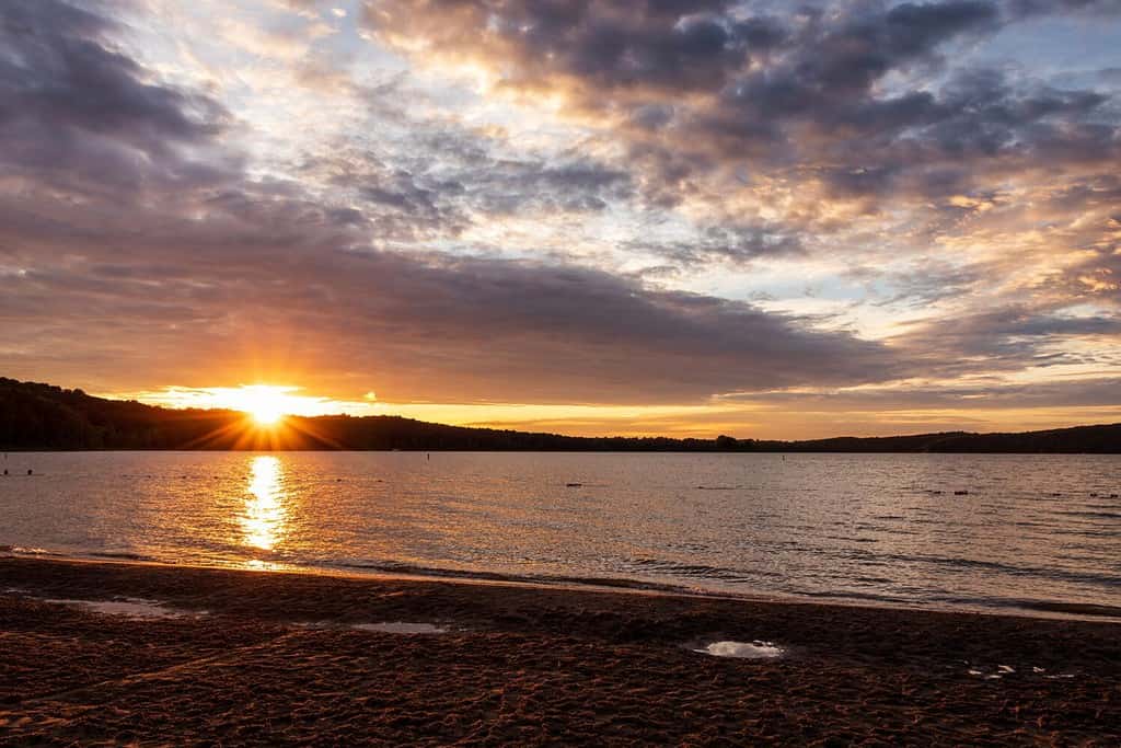 Tramonto con cielo nuvoloso visto dalla riva del lago Patoka