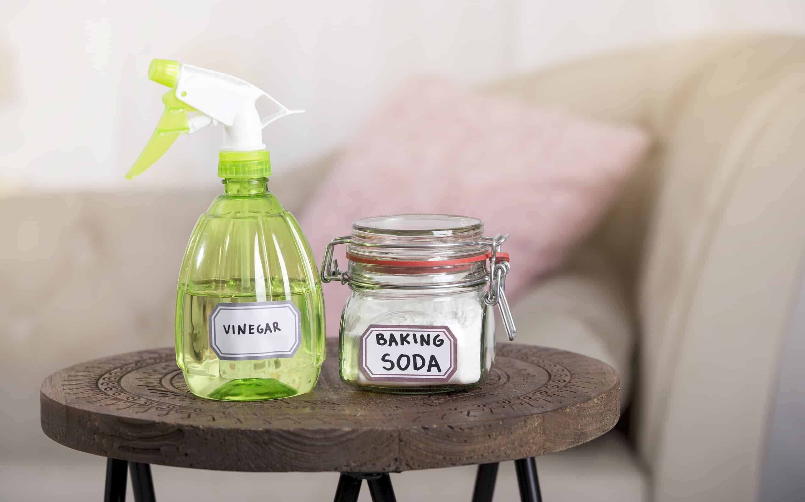 Utilizzo del bicarbonato di sodio, del bicarbonato di sodio e dell'aceto bianco per la pulizia della casa. Aceto bianco in flacone spray e bicarbonato di sodio in barattolo di vetro.
