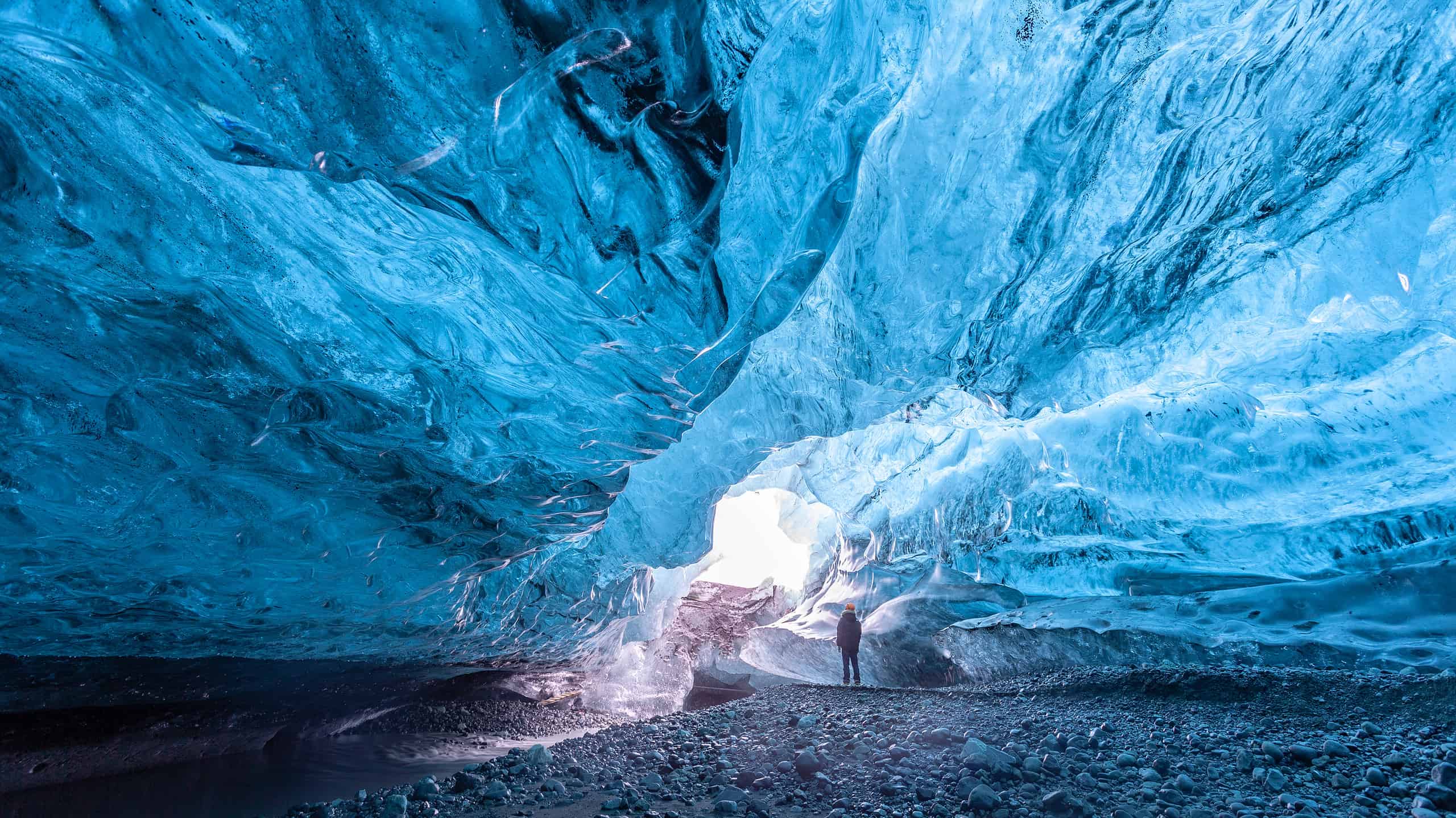 Turista in piedi in una grotta di ghiaccio nel ghiacciaio Vatnajökull Islanda